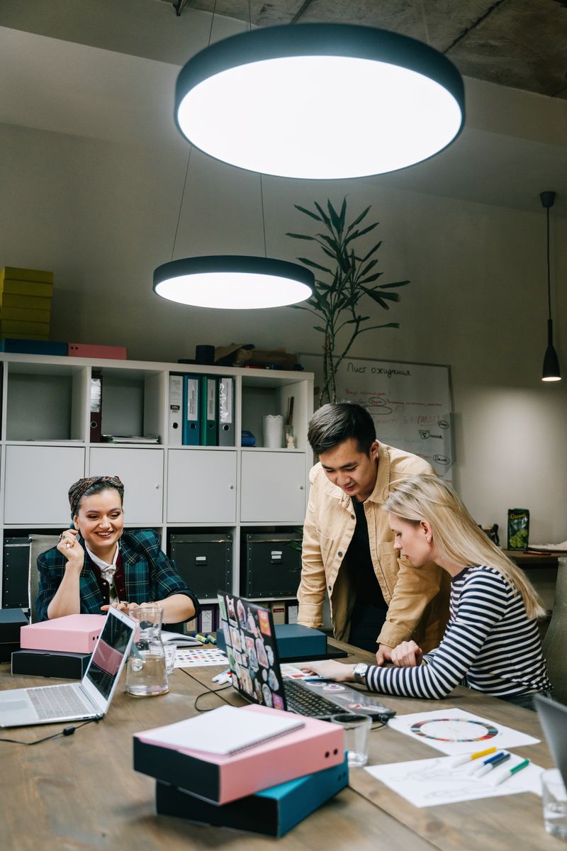 A small sales team working together around a laptop